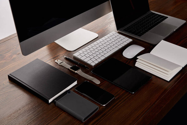 modern workplace with various gadgets on wooden table