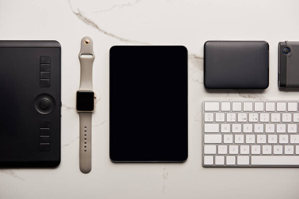 flat lay with various wireless devices on white marble surface