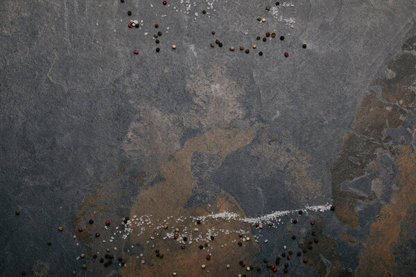 вид сверху на разбросанную соль и специи на сером мраморном фоне
