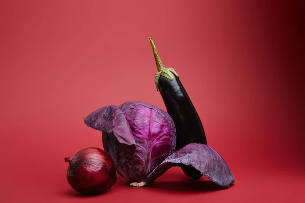 新鲜成熟的有机洋葱 卷心菜和茄子在红色背景 — 免费的图库照片