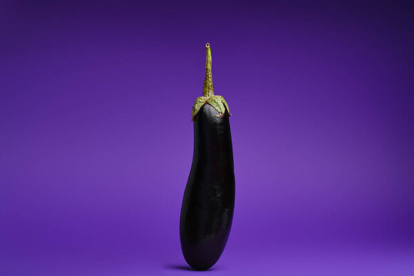 close-up view of fresh ripe organic eggplant on purple background