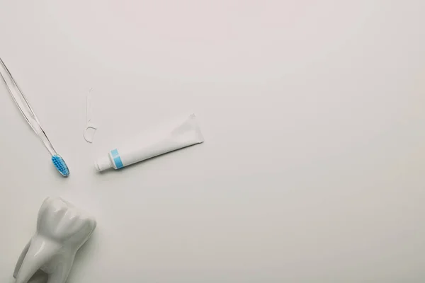 歯ブラシ デンタルフロス歯モデル フラット レイアウトし 白い背景 歯科医療の概念の整理を貼り付ける — ストック写真