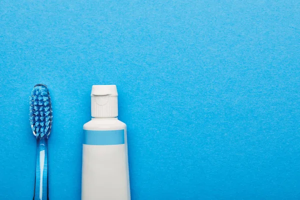 歯ブラシと歯磨き粉歯科コンセプト青い背景上に配置のトップ ビュー — ストック写真