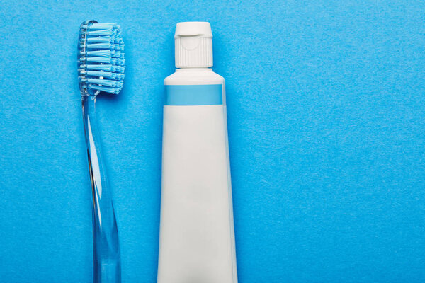 вид сверху на зубную щетку и зубную пасту на синем фоне, концепция стоматологии
