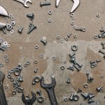 Top view of screws, bolts and wrenches on the background of old  surface