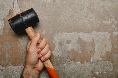 Partial view of man holding mallet on old background  clipart
