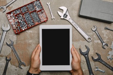 işçi tabloda farklı marangozluk aletleri ile dijital tablet kullanarak görünümünü kırpılmış 