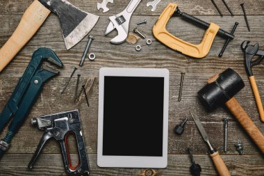Düz lay dijital tablet ve ahşap arka plan üzerinde marangozluk araçlar kümesi ile