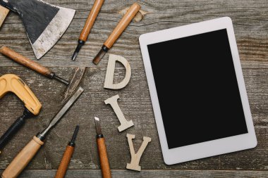 Düz ile dijital tablet, DIY işareti ve farklı marangozluk aletleri ahşap arka plan üzerinde göklere