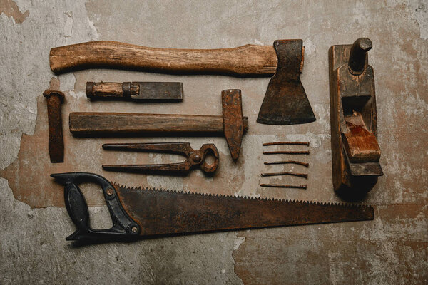 Top view of various rusty carpentry tools on old background