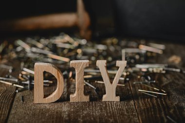 Close up of diy sign on dark wooden table on the background of nails and tools clipart