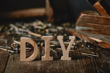 Close up of diy sign on dark wooden table on the background of nails and logs clipart