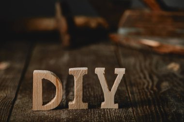 Close up of diy sign on dark wooden table on the background of logs clipart