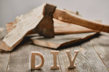 Close up of diy sign on wooden table on the background of logs and axe clipart