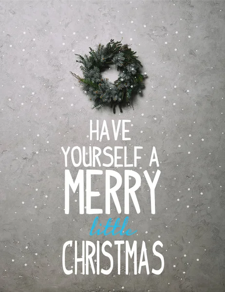 绿色的冷杉花圈圣诞节装饰挂在灰色的墙上 上面挂着 有一个快乐的小圣诞节 的字母和雪 — 免费的图库照片