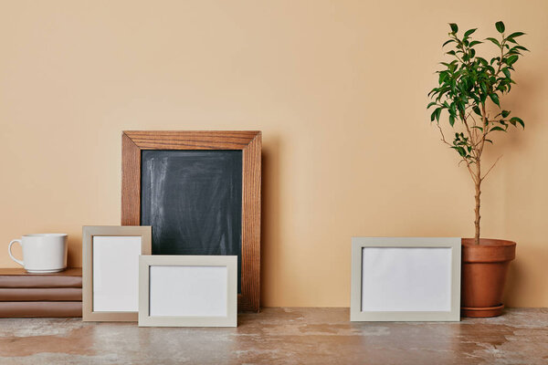 Рамки Ohoto, книги, растение и чашка кофе на бежевом фоне
