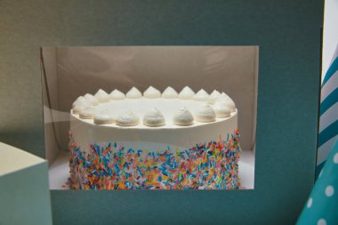 Delicious cake with meringues and sugar sprinkles in box clipart