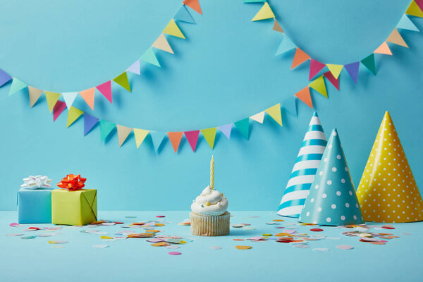  Вкусный кекс, шляпы для вечеринок, конфетти и подарки на голубом фоне с красочной овсянкой
