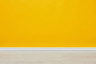background of bright empty yellow wall with wooden floor  clipart