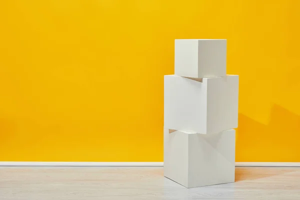 Simples Cubos Yeso Blanco Dispuestos Verticalmente Cerca Pared Amarilla — Foto de Stock