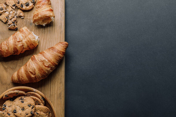 круассаны и печенье с кусочками шоколада в миске на черном столе
