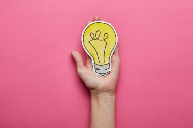 top view of yellow light bulb idea symbol on pink background clipart