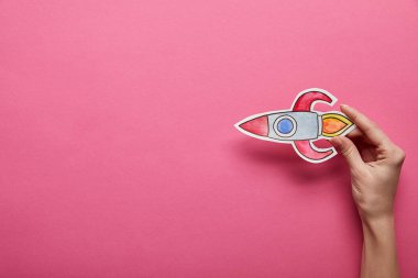 elevated view of flying rocket on pink background clipart