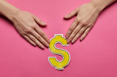 top view of hands holding dollar sign on pink background clipart