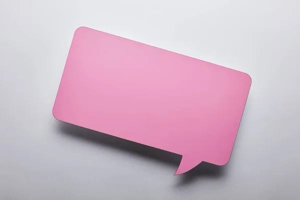 灰色背景上的空白粉红色语音气泡的顶部视图 — 图库照片