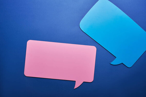 top view of empty blue and pink speech bubbles on blue background