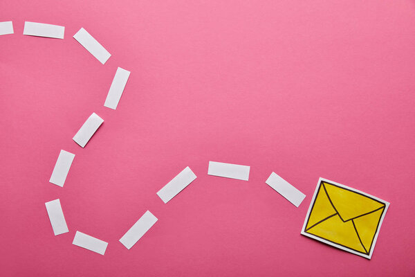 top view of yellow sending delivering email sign on pink background