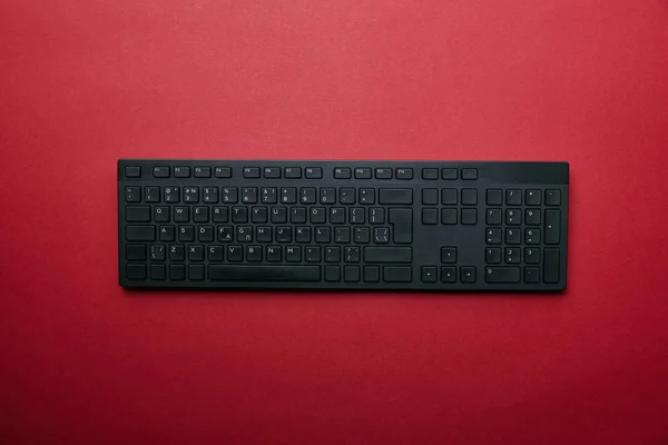 赤の背景に黒のコンピューターのキーボードの上から見る  — 無料ストックフォト