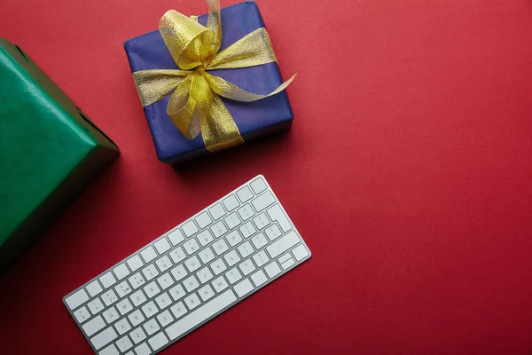 Cropped View Wrapped Gifts White Computer Keyboard Red Background — Free Stock Photo