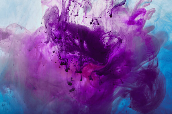 close up view of purple and blue mixing paint swirls