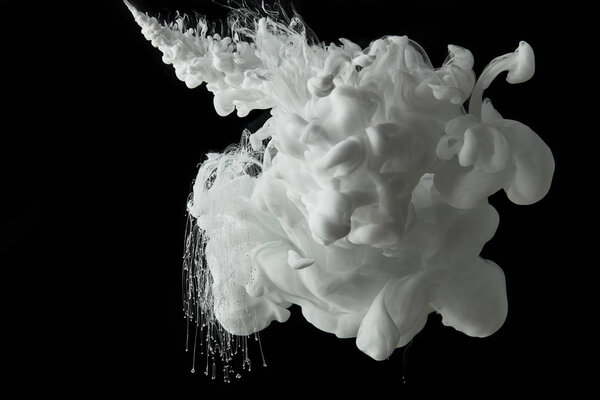 white paint flowing in water on black background