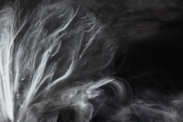 abstract flowing swirls of grey paint on black background