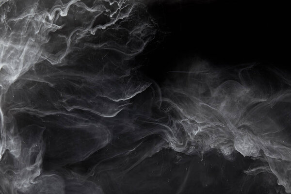 abstract swirls of grey paint on black background