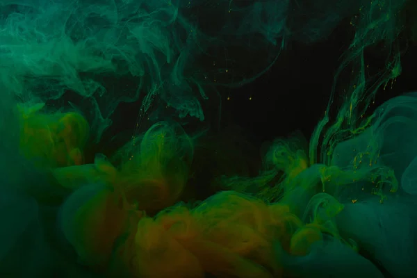用绿色和橙色的油漆漩涡近距离查看抽象背景 — 图库照片