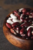 selective focus of raw swallow beans in wooden bowl