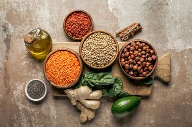 top view of legumes, ginger, chia seeds and avocado on wooden board with rustic background clipart