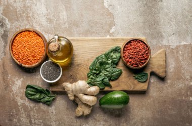 ahşap pano rustik arka plan üzerinde kırmızı mercimek, zencefil, chia tohum ve avokado üstten görünüm