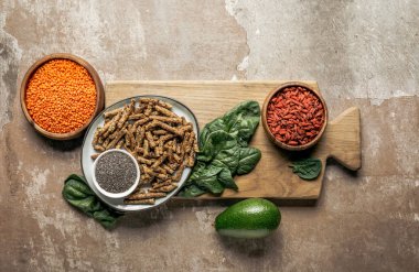 rustik arka plan ile ahşap tahta üzerinde sağlıklı granola, goji Karpuzu, kırmızı mercimek ve ıspanak üstten görünüm