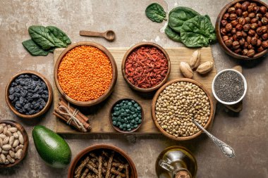 baklagiller, goji meyveleri ve rustik arka plan ile sağlıklı malzemelerle ahşap kurulu üstten görünüm