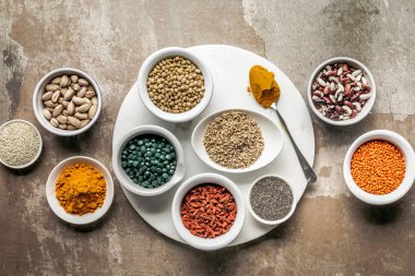 top view of superfoods, nuts and legumes on textured rustic background clipart