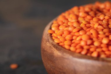 selective focus of red lentils in wooden bowl with copy space clipart