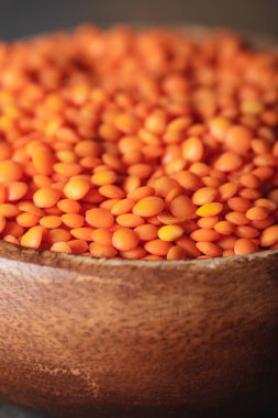 selective focus of red lentils in wooden bowl clipart