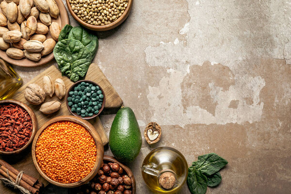 top view of superfoods, legumes, olive oil and healthy ingredients on rustic background with copy space