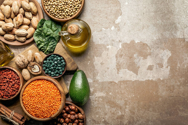 top view of superfoods, legumes, olive oil and healthy ingredients on rustic background with copy space