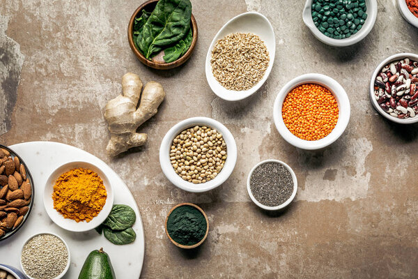 flat lay of superfoods, spices and legumes on textured rustic background