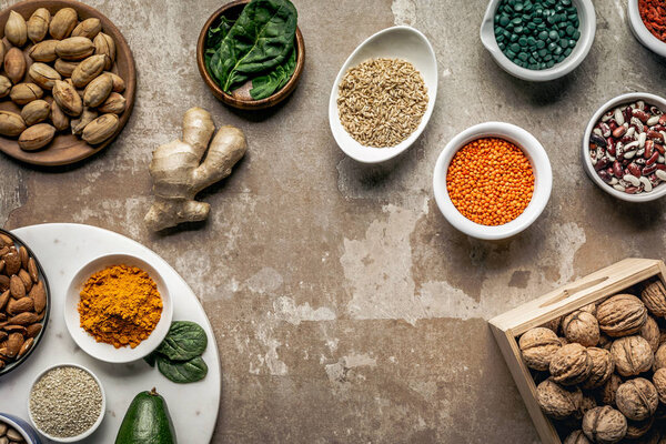 flat lay of spices, legumes, superfoods and nuts on textured rustic background with copy space